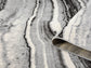 Grey Obsidian Coast monochrome rug, rolled view